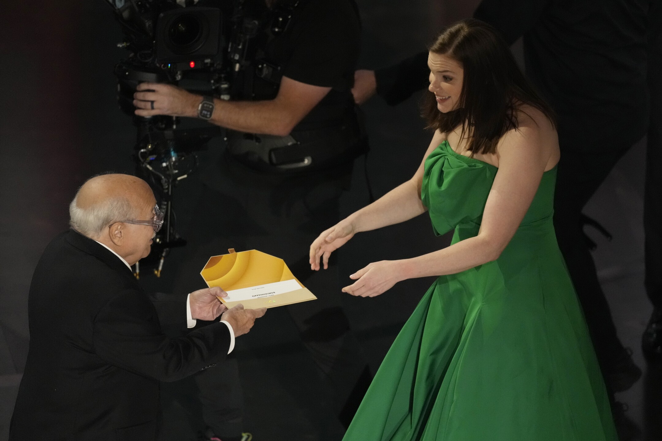 Danny DeVito, left, presents the award for best film editing to Jennifer Lame for "Oppenheimer" during the Oscars on Sunday, March 10, 2024, at the Dolby Theatre in Los Angeles.