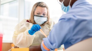 Nurse applies tourniquet to a patient for blood draw