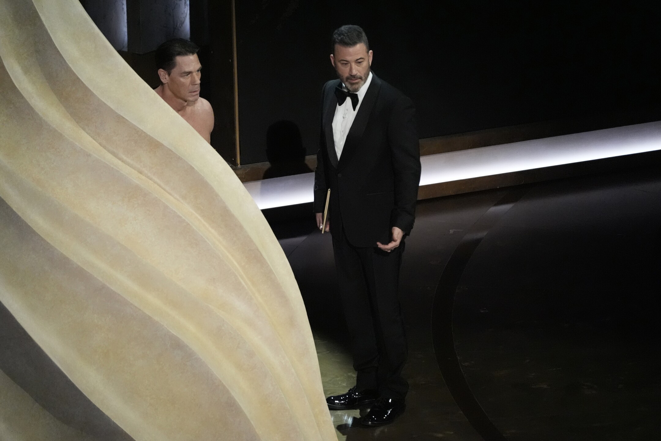 John Cena, left, and Jimmy Kimmel speak during the Oscars on Sunday, March 10, 2024, at the Dolby Theatre in Los Angeles. 